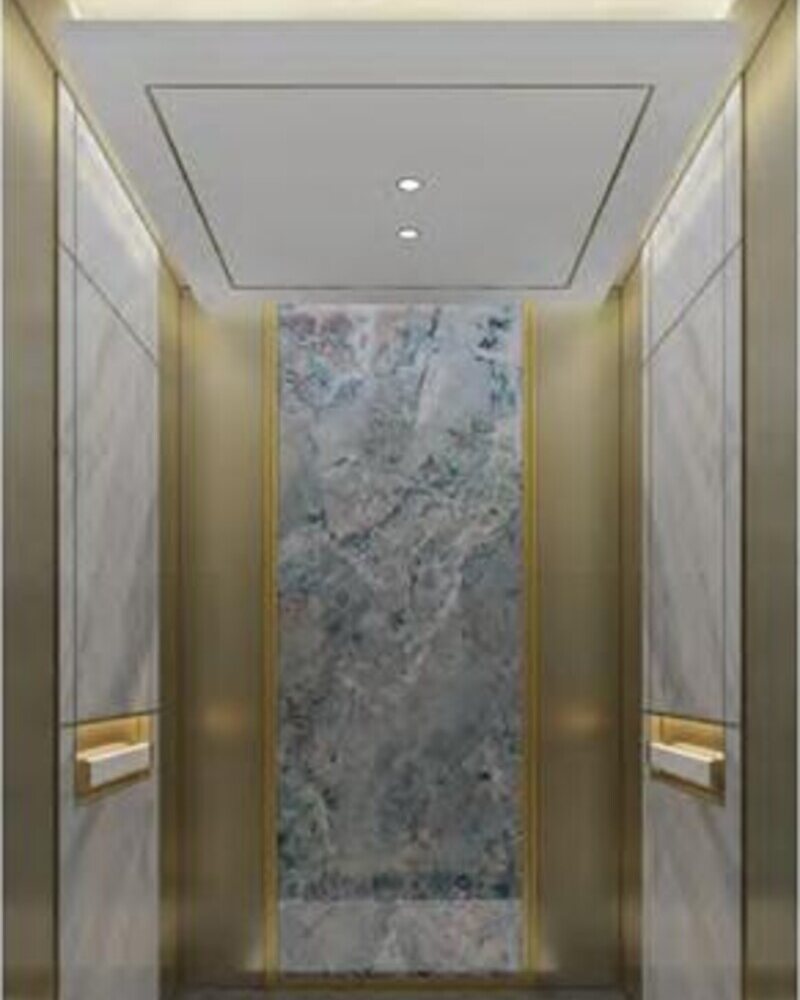 Lift car interior with marble wall panel and titanium-gold trim